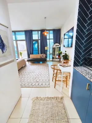 a living room with a couch and a table at Stylish JLT Apartment - Marina Skyline View - Next to Metro - Walk to Beach in Dubai