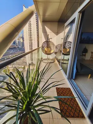 a balcony with chairs and a plant on a building at Stylish JLT Apartment - Marina Skyline View - Next to Metro - Walk to Beach in Dubai