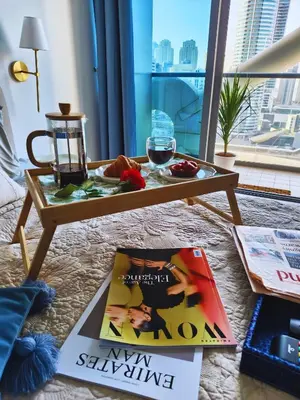 a coffee table with a book and a glass of wine at Stylish JLT Apartment - Marina Skyline View - Next to Metro - Walk to Beach in Dubai