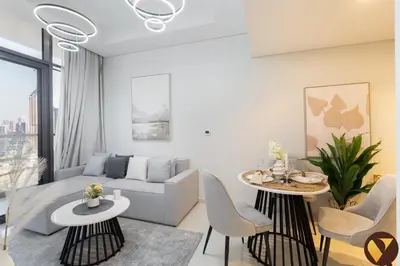 a living room with a couch and a table and chairs at Vogue Business Bay Aykon City Close to Downtown Burj Khalifa and Dubai Mall Burj Khalifa and Dubai Mall, One Bedroom Apartment with Balcony and City View, Access to all Amenities in Dubai