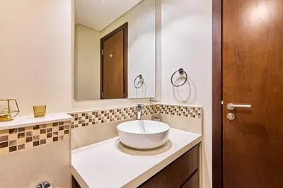 a bathroom with a bowl sink and a mirror at Modern 2BR Retreat Canal Views Near Downtown in Dubai