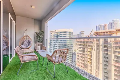 a balcony with chairs and a table and a view of a city at Modern 2BR Retreat Canal Views Near Downtown in Dubai