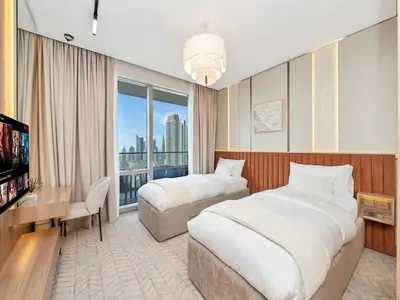 a hotel room with two beds and a television at 2 Bedroom Luxury Burj Khalifa & Fountain View Connected to Dubai Mall in Dubai