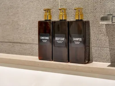 three bottles of soap sitting on a shelf at 2 Bedroom Luxury Burj Khalifa & Fountain View Connected to Dubai Mall in Dubai