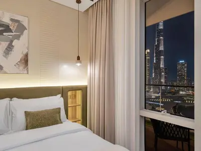 a bedroom with a bed and a view of a city at 2 Bedroom Luxury Burj Khalifa & Fountain View Connected to Dubai Mall in Dubai