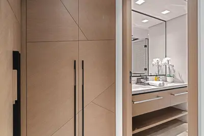 a bathroom with a wooden door with a sink and a mirror at Creek Escape - Palace Residences - Creek Harbour in Dubai