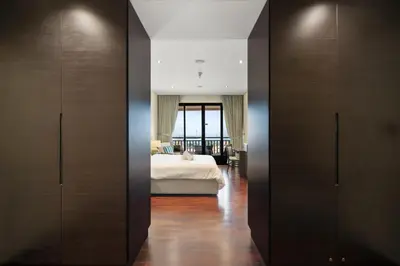 a bedroom with a bed and wooden cabinets at Palm Retreat - Anantara North - Palm Jumeirah in Dubai