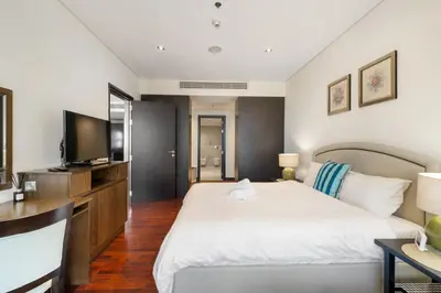 a bedroom with a large bed and a flat screen tv at Palm Retreat - Anantara North - Palm Jumeirah in Dubai