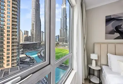 a bedroom with a window with a view of a city at SanctuaryStays - A Luxury apartment with Full Burj Khalifa and Dubai Fountain Views - Dubai Mall Access in Dubai