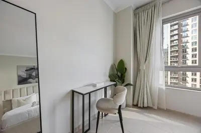 a bedroom with a desk and a bed and a window at SanctuaryStays - A Luxury apartment with Full Burj Khalifa and Dubai Fountain Views - Dubai Mall Access in Dubai