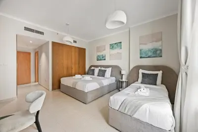 a bedroom with two beds and a chair at SanctuaryStays - A Luxury apartment with Full Burj Khalifa and Dubai Fountain Views - Dubai Mall Access in Dubai