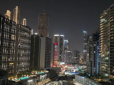 a city skyline at night with tall buildings at High Floor Balcony Suite 8 mins to Burj Khalifa in Dubai