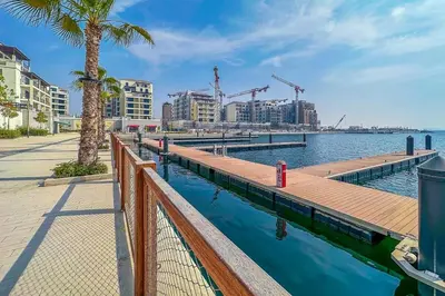 a dock with a walkway next to a body of water at Cozy 3BR Sea-View Apartment in La Rive 1 in Dubai