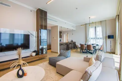 a living room with a couch and a large tv at Cozy 3BR Sea-View Apartment in La Rive 1 in Dubai