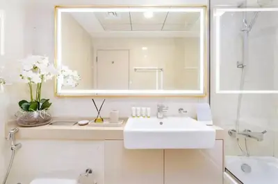 a white bathroom with a sink and a mirror at Elegant 1BR Apartment with Partial Sea View by EE holiday homes in Dubai
