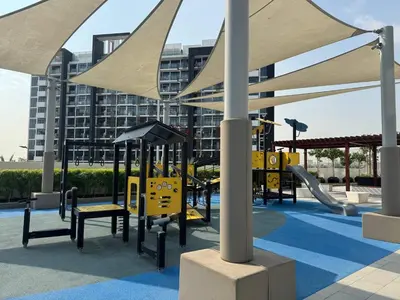 a playground with a slide and swings at Greige & Spacious Studio in Dubai