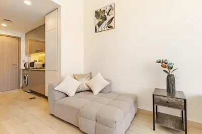 a living room with a couch and a table at Greige & Spacious Studio in Dubai