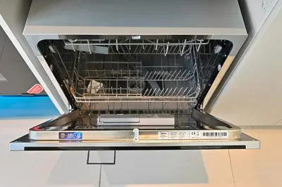a dishwasher with the door open with dishes in it at Golden Stays - Elegant 4BR I Santorini-Style I Sunsets & Comfort in Dubai
