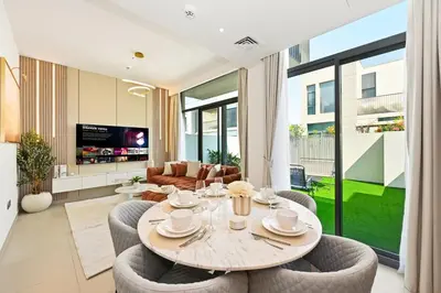 a living room with a table and chairs at Golden Stays - Elegant 4BR I Santorini-Style I Sunsets & Comfort in Dubai
