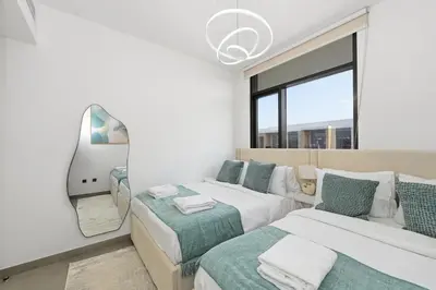 a white room with two beds and a couch at Golden Stays - Stylish 4BR Villa I Garden, Pool & Parking I Global Village in Dubai