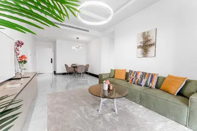 a living room with a green couch and a table at Luxury 1BR Terraces Private Jacuzzi Business Bay in Dubai