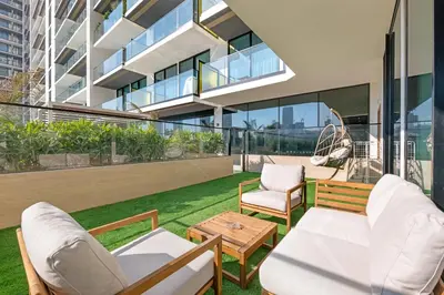 a patio with chairs and a table on a building at Waves - Comfy and Stylish 1BR with Huge Balcony in Dubai