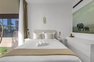 a bedroom with a bed with two towels on it at Waves - Comfy and Stylish 1BR with Huge Balcony in Dubai