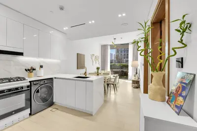 a white kitchen with a stove and a dishwasher at Waves - Comfy and Stylish 1BR with Huge Balcony in Dubai