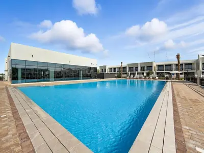 a large swimming pool in front of a building at Golden Stays - Chic 4BR Retreat I Luxe Touches & Serene Views in Dubai