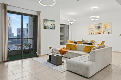 a living room with a couch and a table at Stylish 3BR JBR l Steps to Beach l Balcony l Sleeps 6 in Dubai