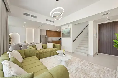 a living room with a couch and a table at Golden Stays - Modern Luxe 4BR Oasis I Peaceful Views in Dubai