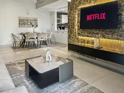 a living room with a tv on a wall at Breathtaking 2BR in Marina - Steps to Metro in Dubai