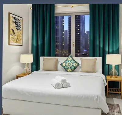a bedroom with a large white bed with green curtains at Breathtaking 2BR in Marina - Steps to Metro in Dubai