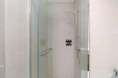 a shower with a glass door in a bathroom at Chic Urban Studio l Poolside Living l Balcony in Dubai