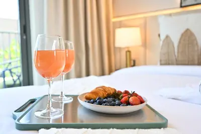a tray with a plate of food and two glasses of wine at Golden Stays - Tranquil 4BR Villa I Pool & Coastal Charm in Dubai