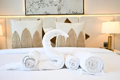 a pile of towels sitting on top of a bed at Golden Stays - Tranquil 4BR Villa I Pool & Coastal Charm in Dubai