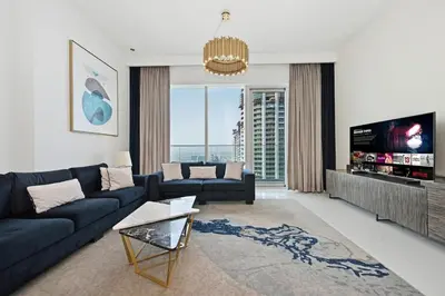 a living room with a couch and a tv at Golden Stays - Palm Views I Luxe 4BR Getaway I Tranquil Charm in Dubai