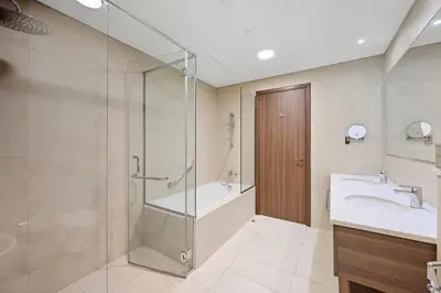 a bathroom with a shower and a sink and a tub at Golden Stays - Palm Views I Luxe 4BR Getaway I Tranquil Charm in Dubai