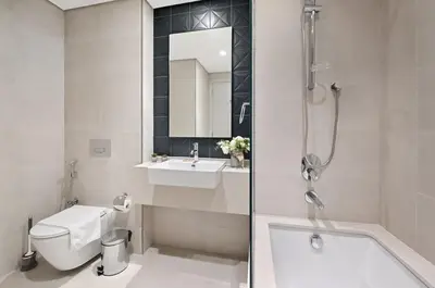 a bathroom with a toilet and a sink and a shower at Golden Stays - Italian Riviera 4BR Villa I Stylish Bliss Living in Dubai