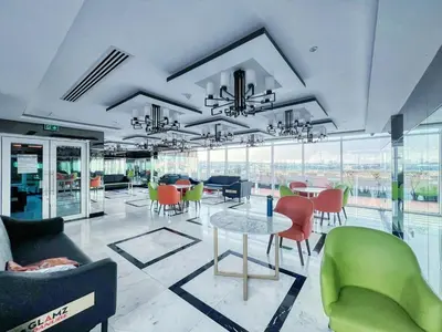 a room with a table and chairs and windows at GuestReady - Studio l Close to Metro Station in Dubai