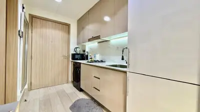 a kitchen with a white refrigerator and a sink at Luxury Stay in Meydan - 10min to Downtown in Dubai