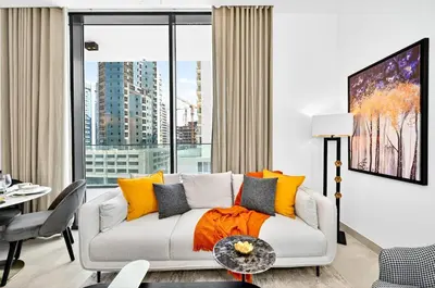 a living room with a couch and a large window at Golden Stays - Luxe 1BR Retreat I Cinema Access & Elegant Stay in Dubai