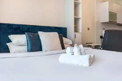 a white bed with towels on top of it at GuestReady - Burj Khalifa View l Rooftop Pool in Dubai