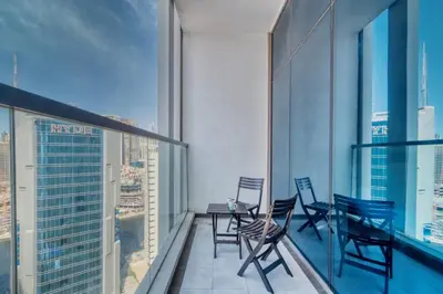 a balcony with chairs and tables on a building at GuestReady - Burj Khalifa View l Rooftop Pool in Dubai