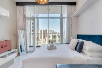 a bedroom with a large white bed and a large window at GuestReady - Burj Khalifa View l Rooftop Pool in Dubai