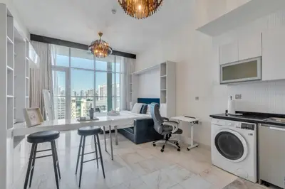 a kitchen with a desk and a washing machine in a room at GuestReady - Burj Khalifa View l Rooftop Pool in Dubai