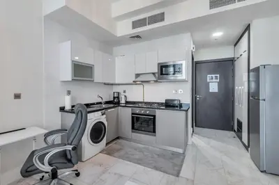 a kitchen with a stove and a chair in it at GuestReady - Burj Khalifa View l Rooftop Pool in Dubai