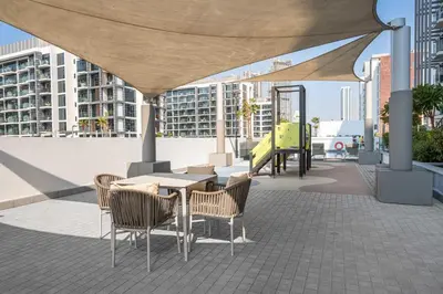 a patio with a table and chairs under a canopy at StayShort - Studio Apartment at Azizi Riviera with Balcony in Dubai