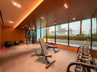 a gym with two chairs and a large window at GuestReady | 2 BR | Luxury Apt with Private Pool in Dubai