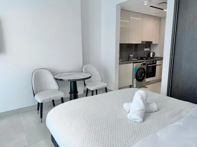 a bedroom with a bed and a table and chairs at Modern studio in the centre of Dubai in Dubai